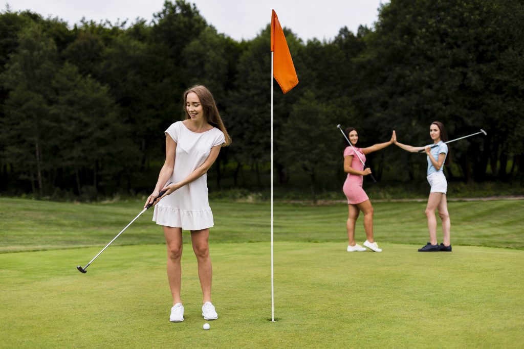 full shot pretty girls playing golf